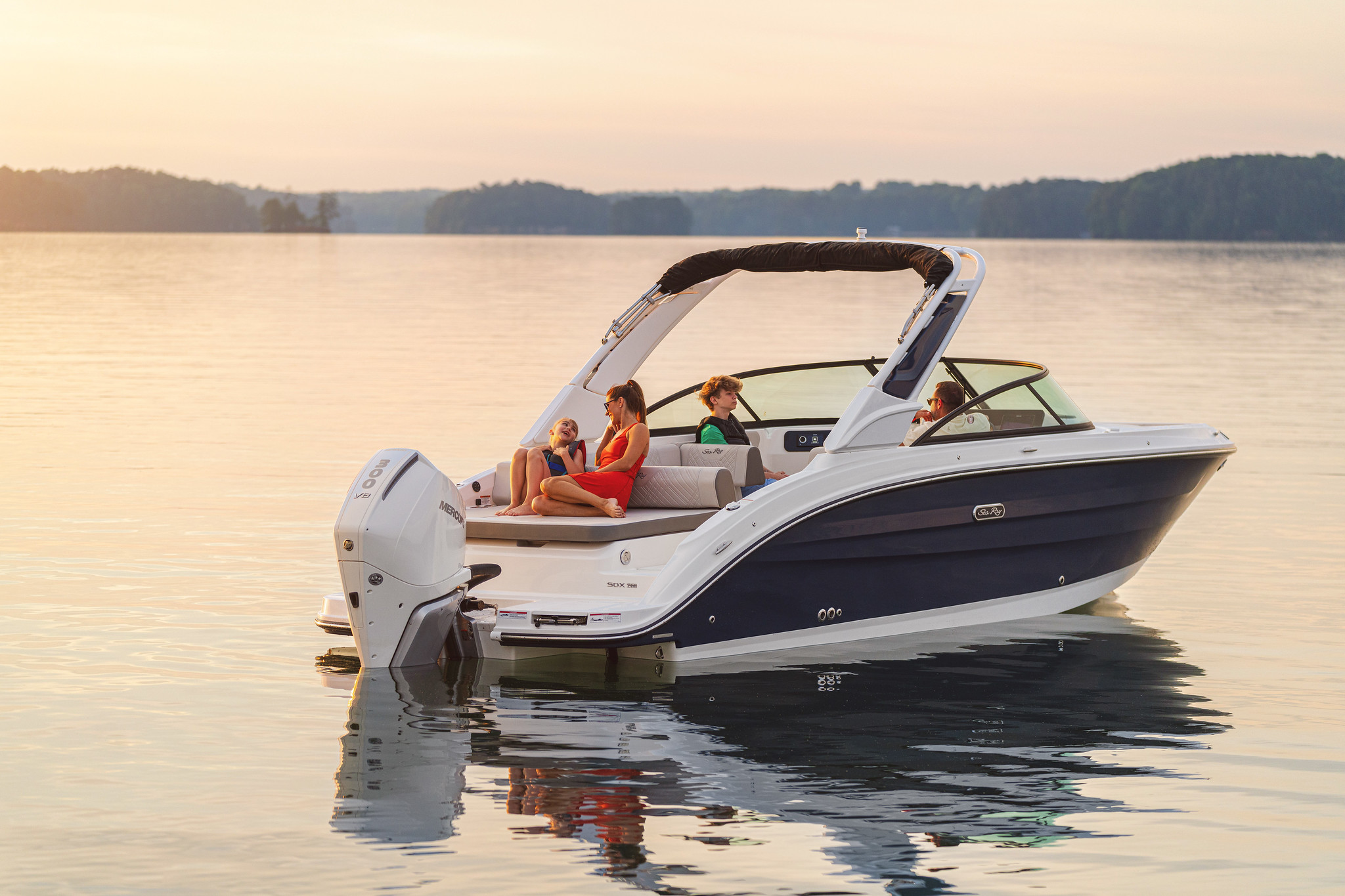 Family aboard an SDX 250 Outboard at sunset